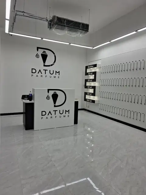 DATUM PARFUME: интерьерный логотип на стене, брендированная стойка ресепшен и подсвеченные полки «Bottles»