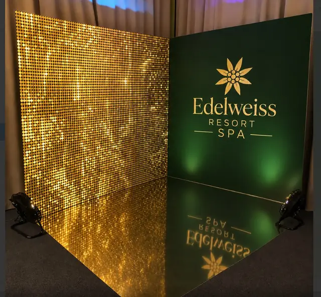 Edelweiss Resort SPA: фотозона: стена из пайеток и брендированная панель с логотипом