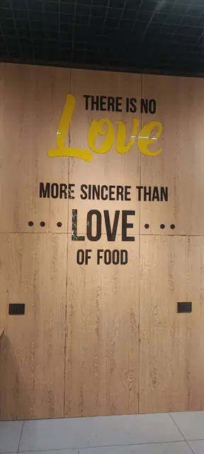 There is no Love more sincere than love of food: интерьерная надпись из объёмных букв на стеновой панели под дерево