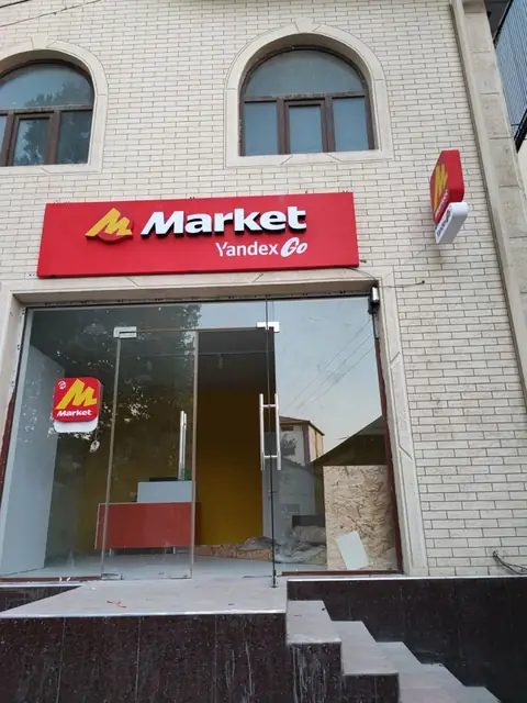 Market Yandex Go: световой короб на фасаде, торцевая консоль и наклейка на дверь пункта выдачи