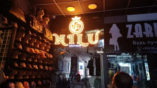 NILU BOUTIQUE: световая вывеска и золотые буквы на реечной колонне в бутике