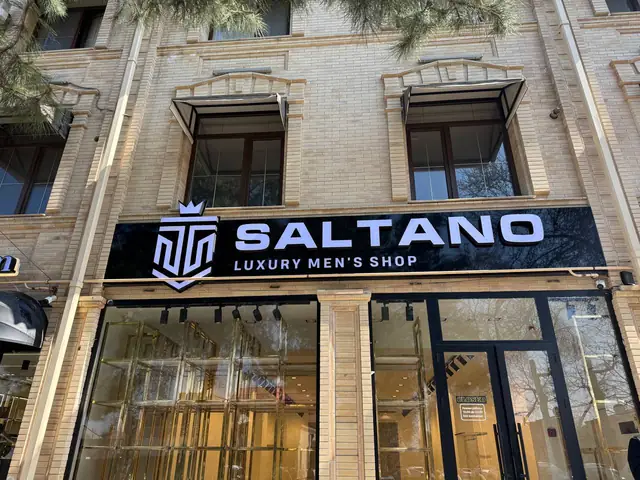 SALTANO: объёмные световые буквы и логотип на чёрной панели над магазином