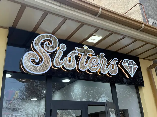 Sisters: световая вывеска со стразовыми буквами и оклейка входных дверей