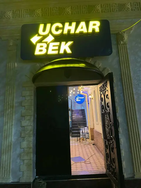Uchar Bek: световые буквы, вертикальная вывеска с лайтбоксами, навигация у входа и карта мира с подсветкой