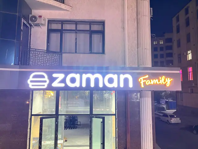 zaman Family: световые буквы с логотипом на козырьке входа