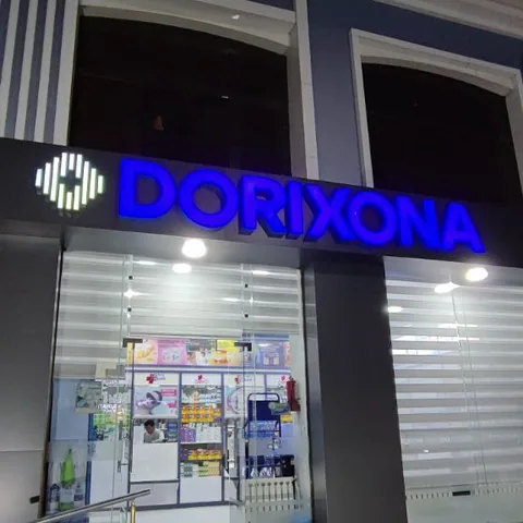 Синие световые буквы Dorixona над входом в аптеку вечером