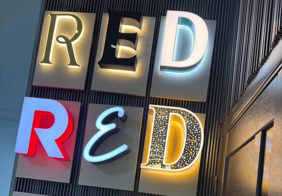 Образцы букв RED на стене: часть светится лицом, часть даёт ореол на стену