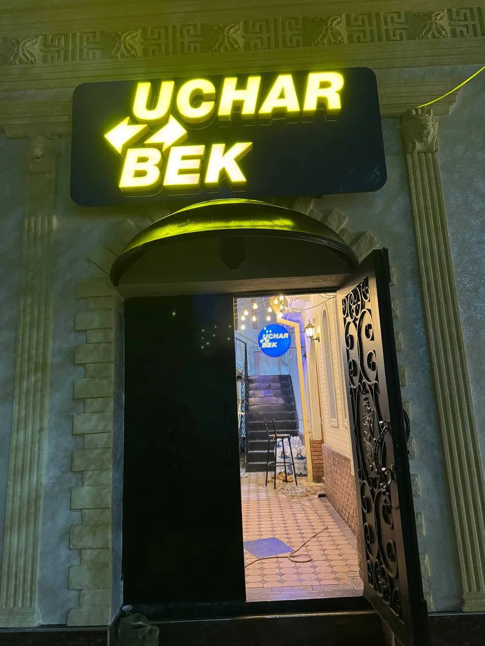 Световой короб Uchar Bek над входом ночью